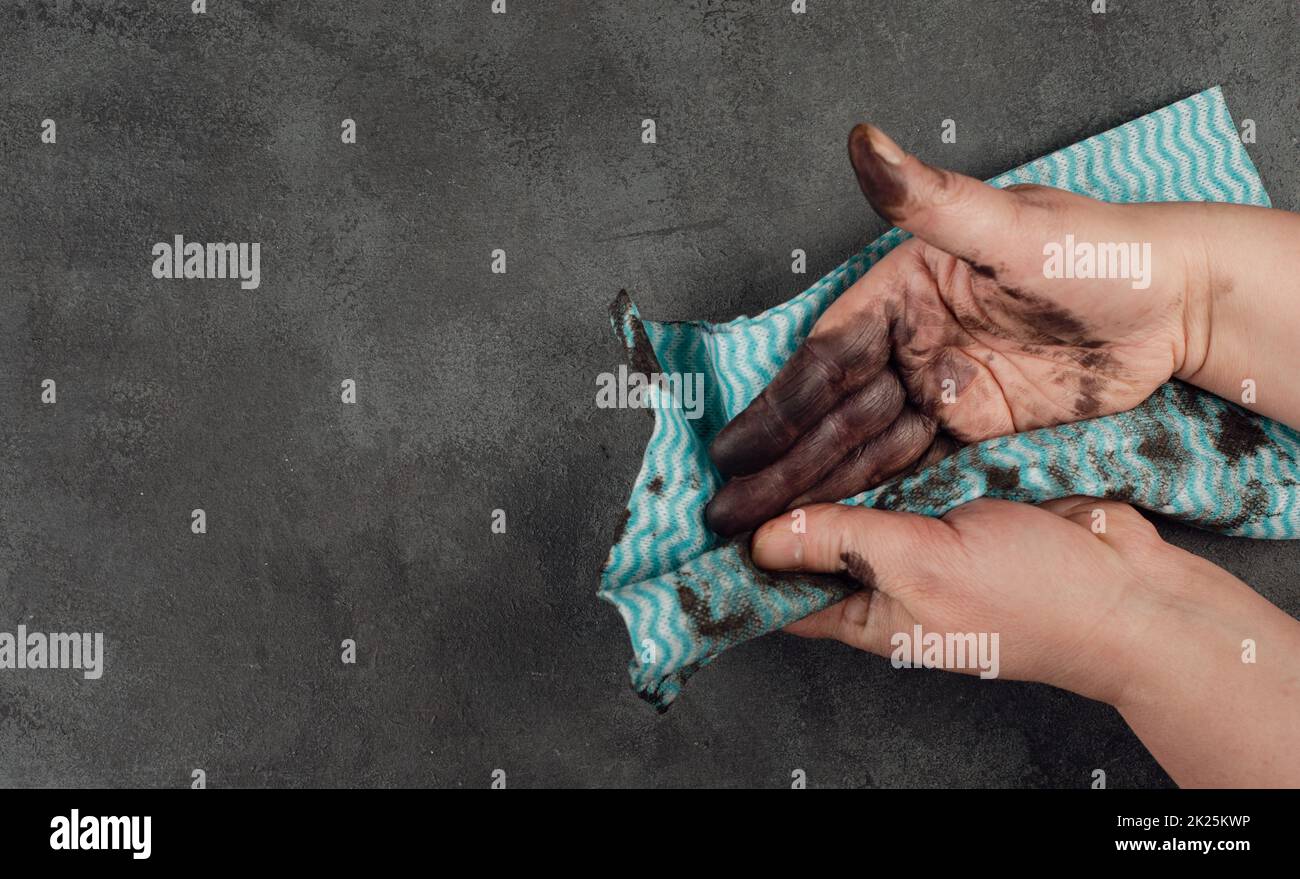 Cleaning dirty hands with a piece of clothes, fuel oil, mechanic worker, repair service, dark background Stock Photo