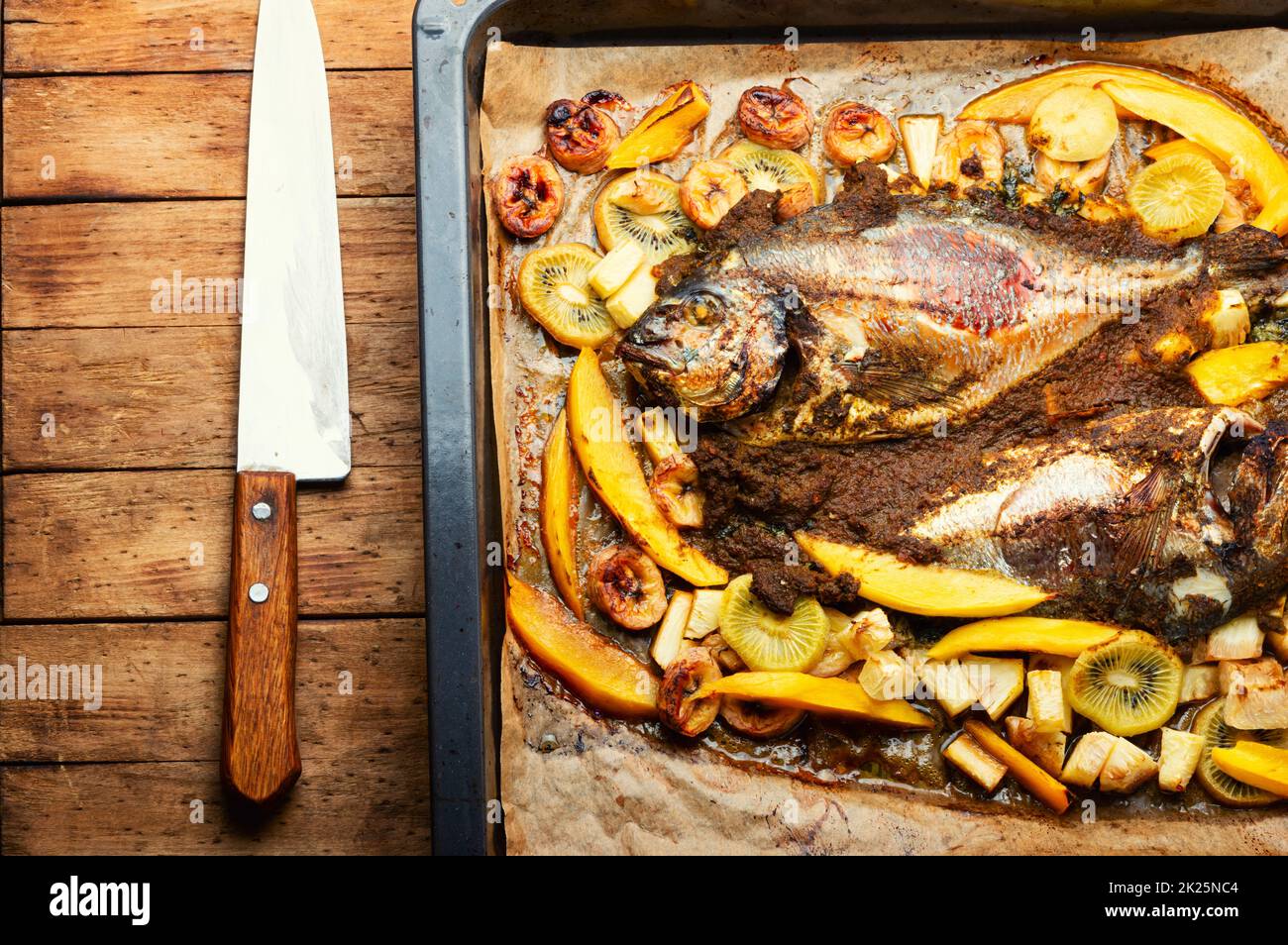 Baked gilthead fish in fruit. Stock Photo