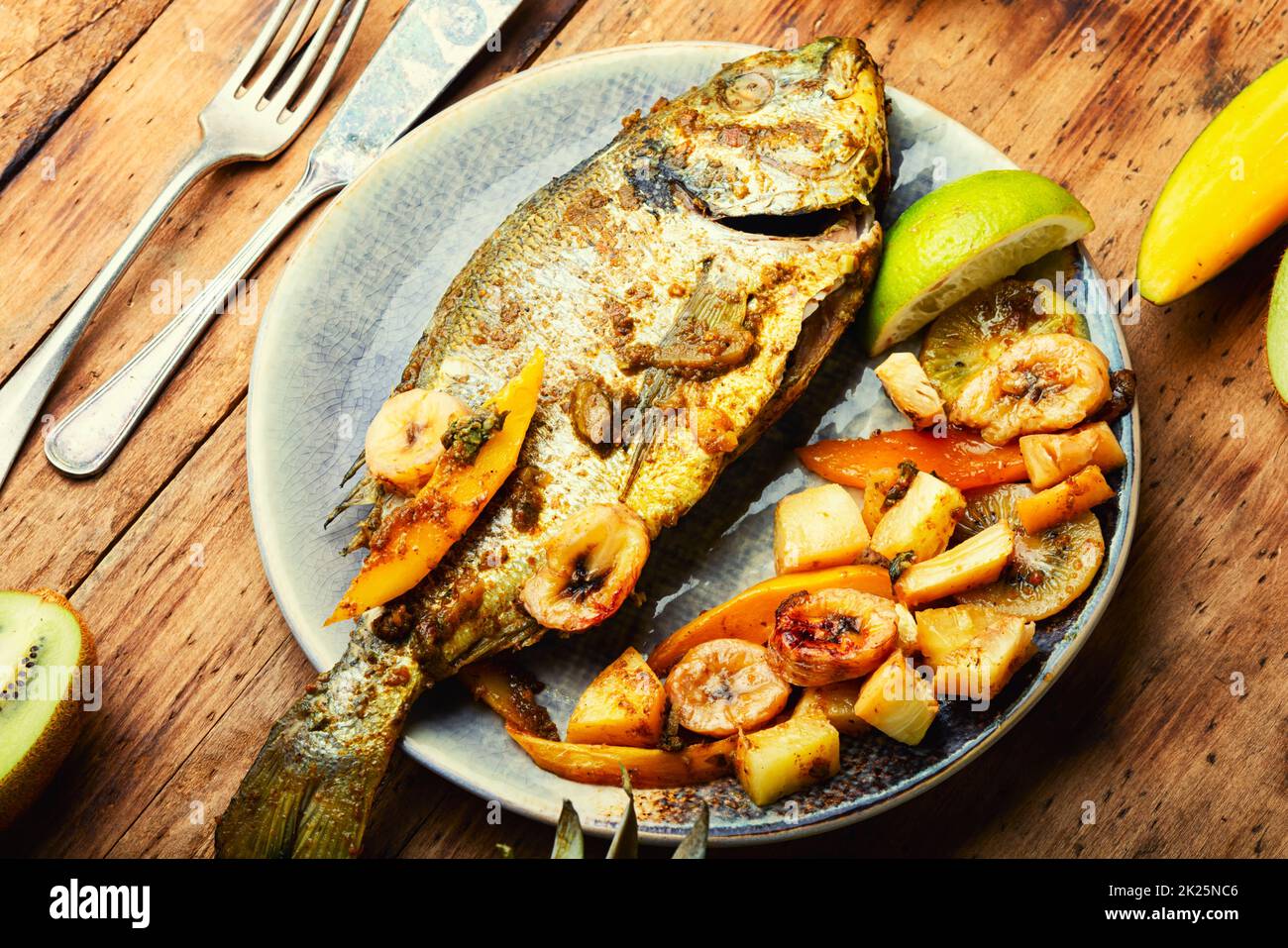 Baked gilthead fish in fruit. Stock Photo