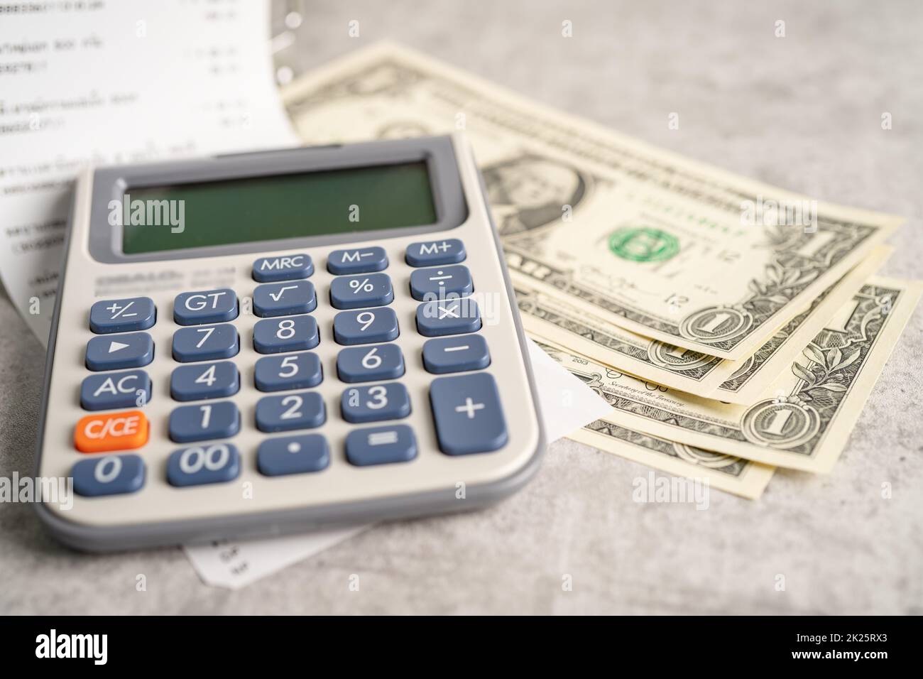 Grocery shopping list receipts with calculator and US dollar banknotes money. Stock Photo