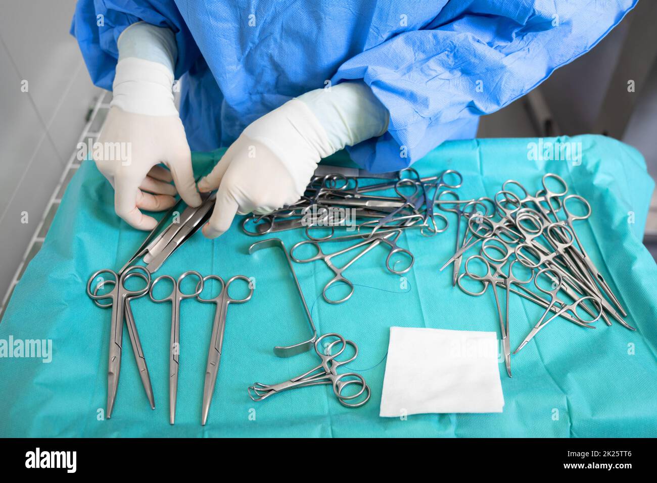 Multiple surgery instruments on blue table above view. surgeon take surgical tools from table. Stock Photo
