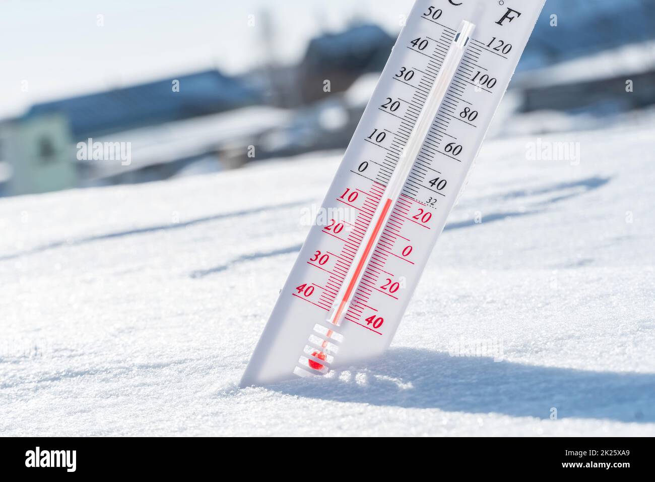 The thermometer lies on the snow in winter showing a negative temperature.Meteorological conditions in a harsh climate in winter with low air and ambient temperatures.Freeze in wintertime.Sunny winter Stock Photo