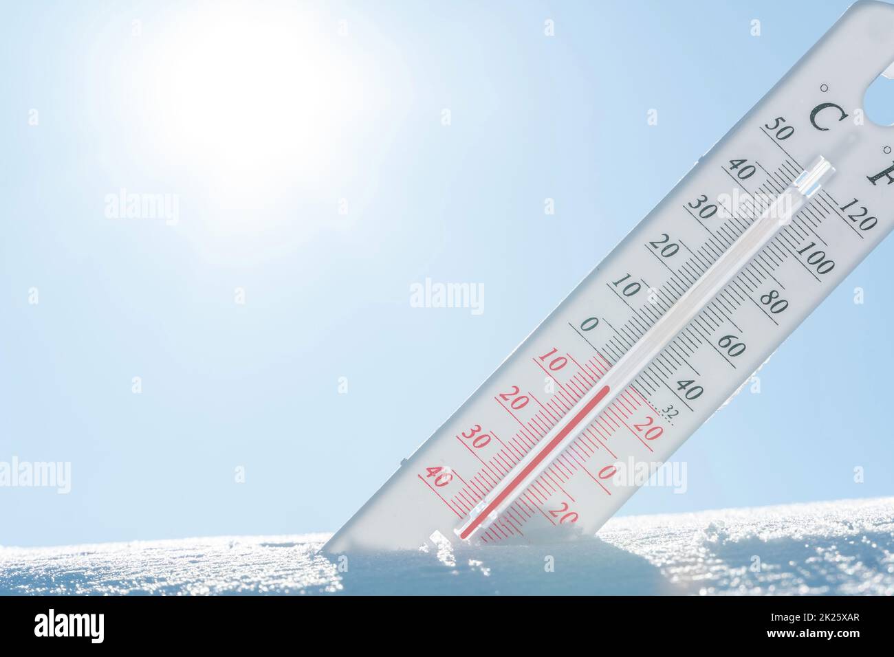 In winter or spring the thermometer lies on the snow and shows a negative temperature in cold weather.Meteorological conditions with low air and ambient temperatures.Climate change and global warming Stock Photo