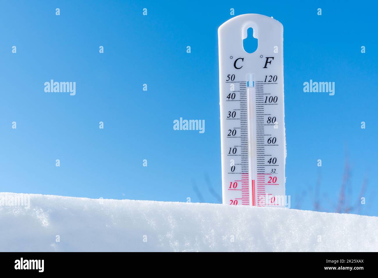 The thermometer in winter lies on the snow and shows low negative air temperature. Meteorological conditions in the harsh climate in the northern regions and the environment.Climate change on Earth Stock Photo