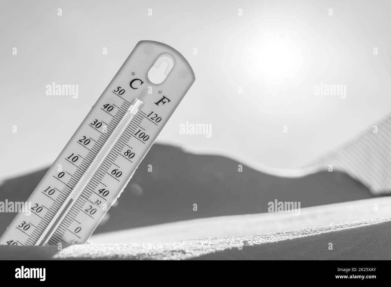 The thermometer lies on the snow in winter showing a negative
