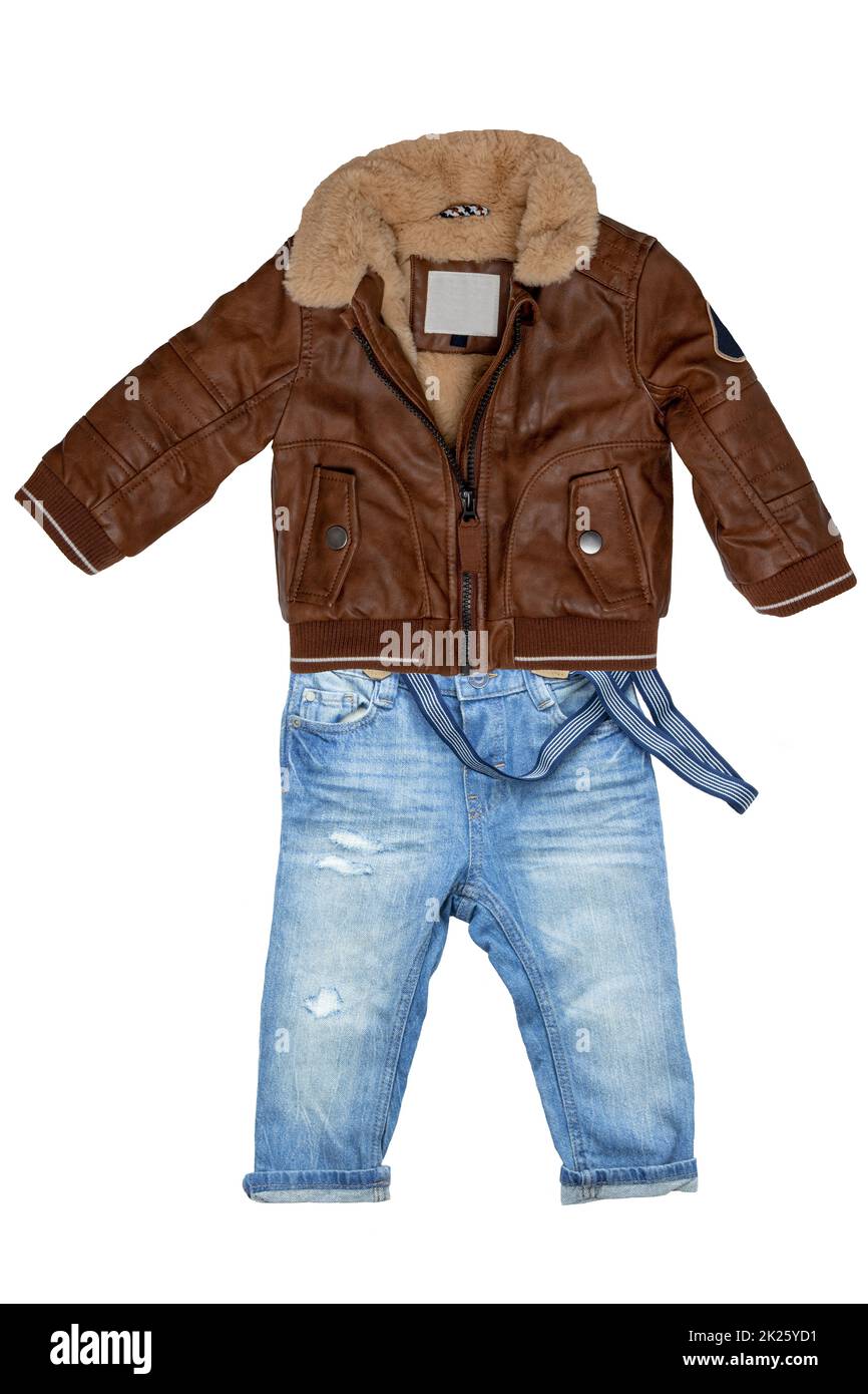 Closeup of a trendy stylish brown leather jacket with fur and a blue denim pants or trousers for child boy isolated on a white background. Jeans autumn fashion. Stock Photo
