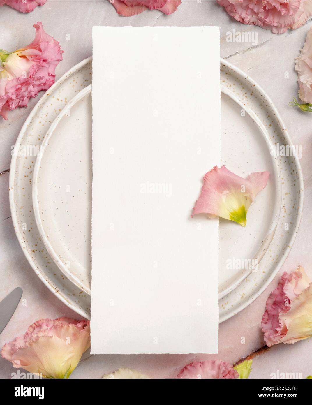 Wedding menu laying on a ceramic plate on a marble table Stock Photo