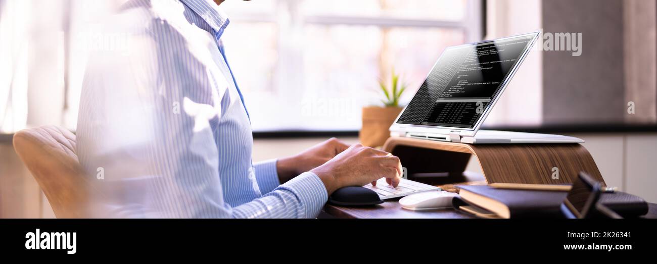 African American Coder Using Computer At Desk Stock Photo