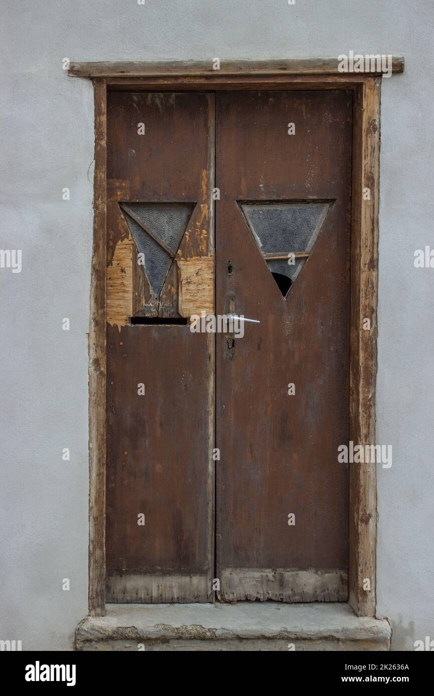 Old battered wooden door with broken glass Stock Photo