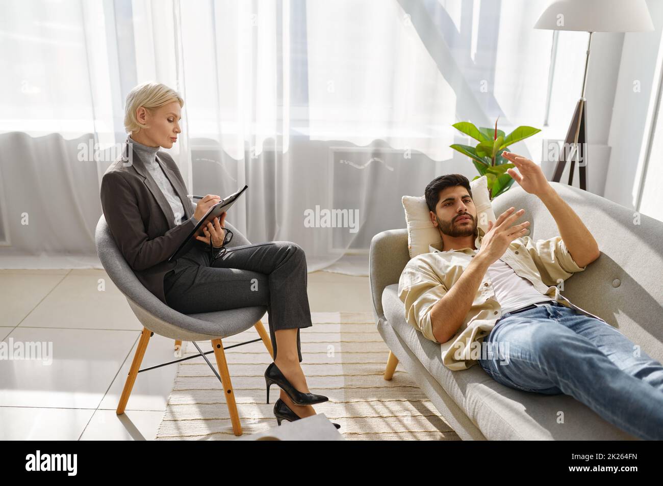 Female psychologist working with man on couch Stock Photo
