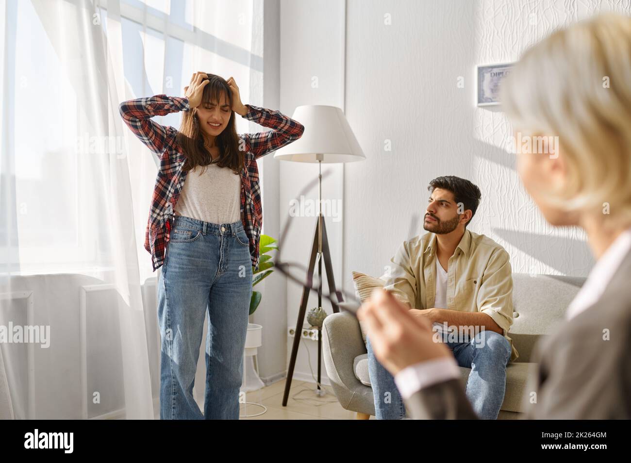 Unhappy couple arguing disagreement at psychologists office Stock Photo