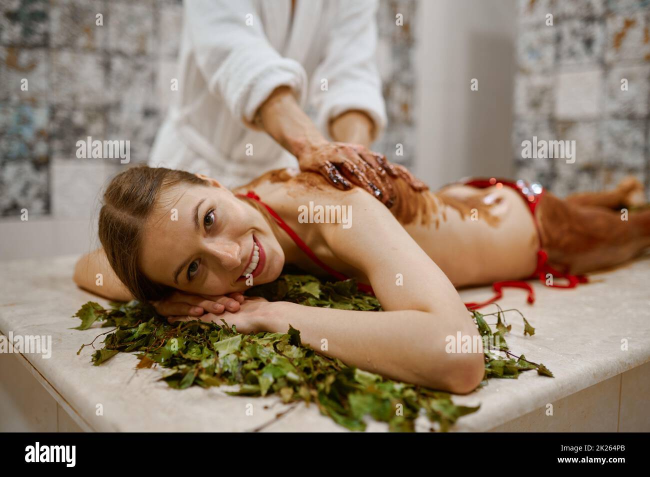 Young woman getting honey massage in sauna Stock Photo