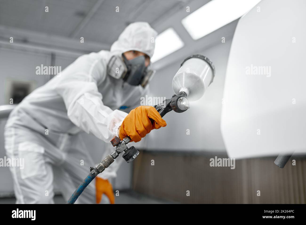Painter in protective mask painting automobile door Stock Photo Alamy