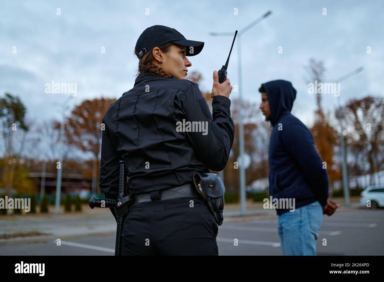 Woman cop using portable radio back view Stock Photo