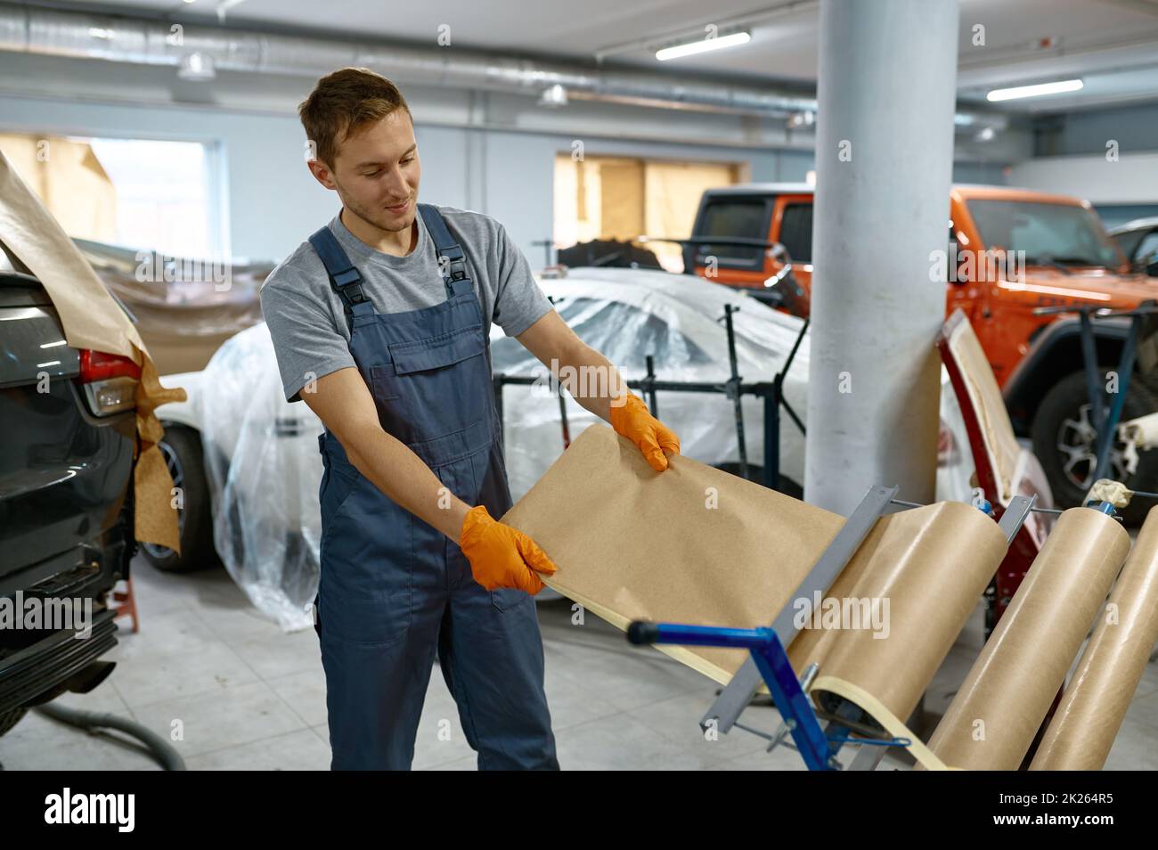 Car repair service workman taking wrapping paper Stock Photo