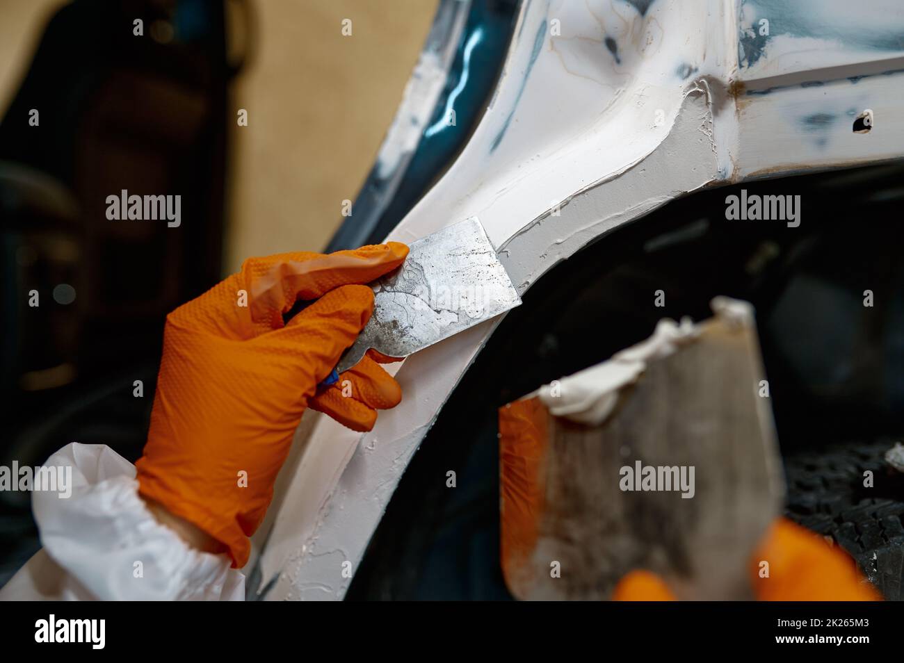 Mechanic puttying plastering car body in garage Stock Photo Alamy