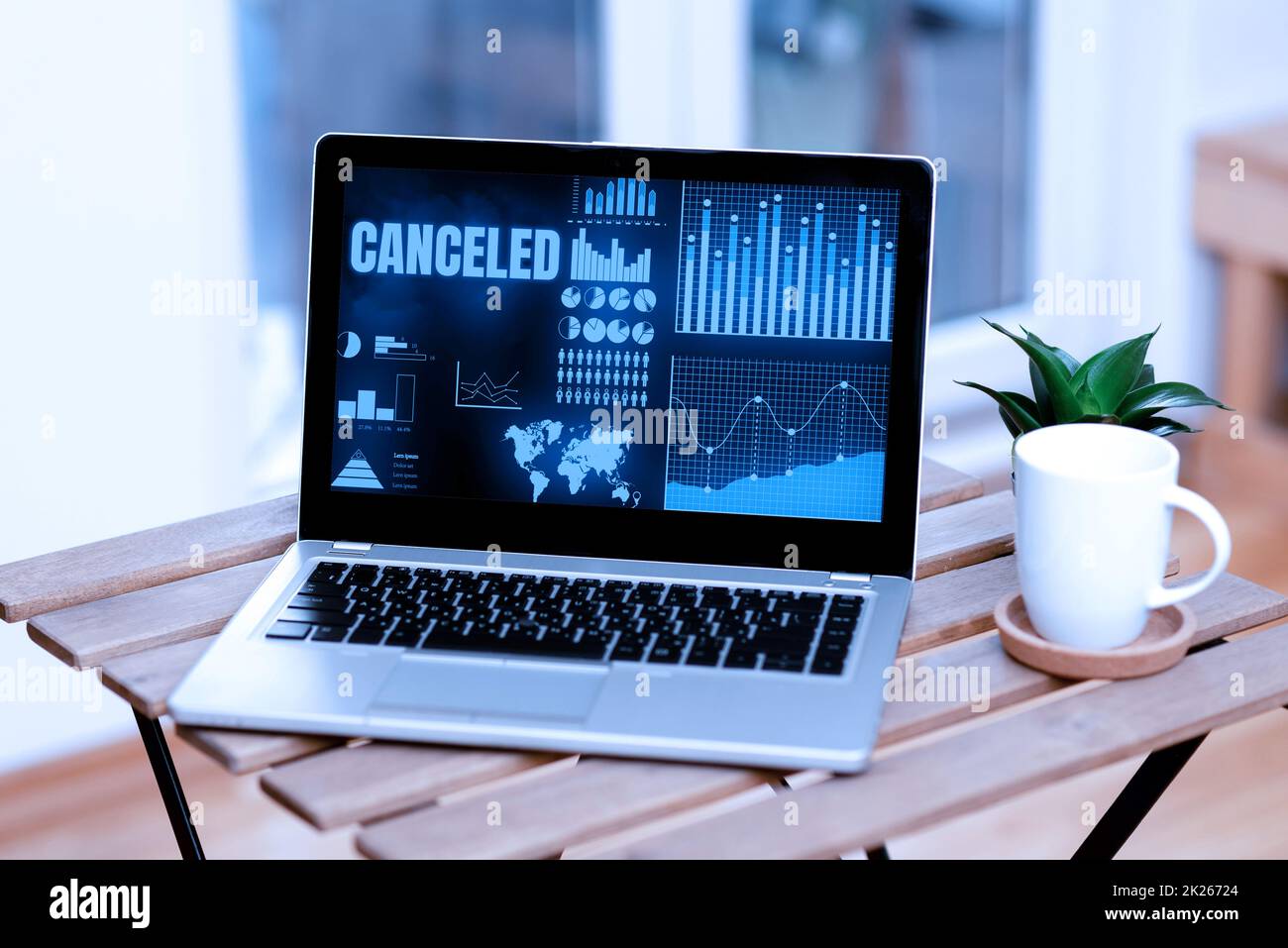 Hand writing sign Canceled. Word Written on to decide not to conduct or perform something planned or expected Laptop Resting On A Table Beside Coffee Mug And Plant Showing Work Process. Stock Photo