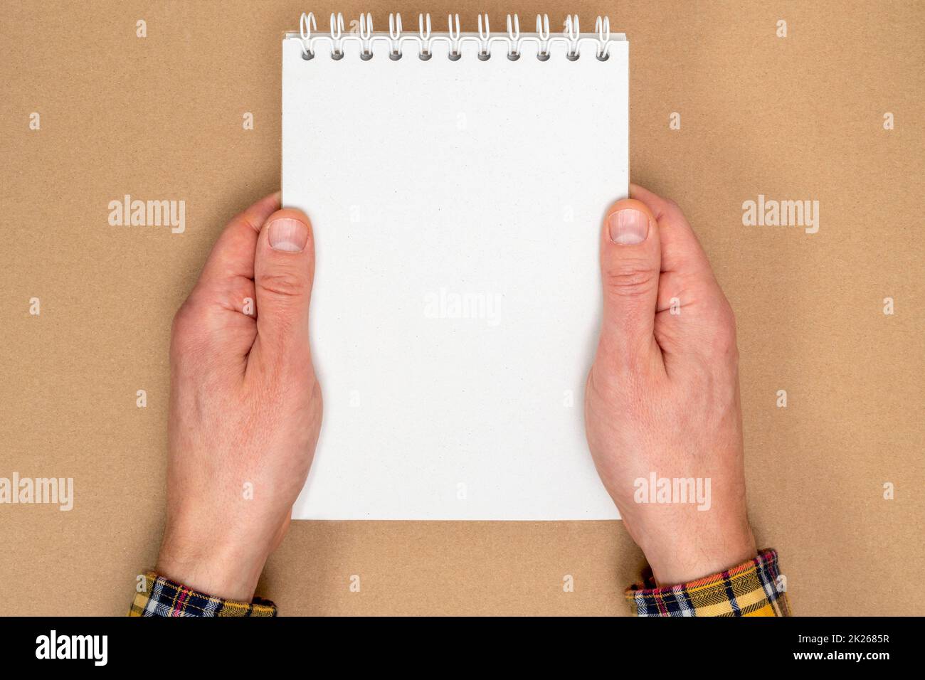 Hands holding a spiral notebook with blank sheets for writings Stock Photo
