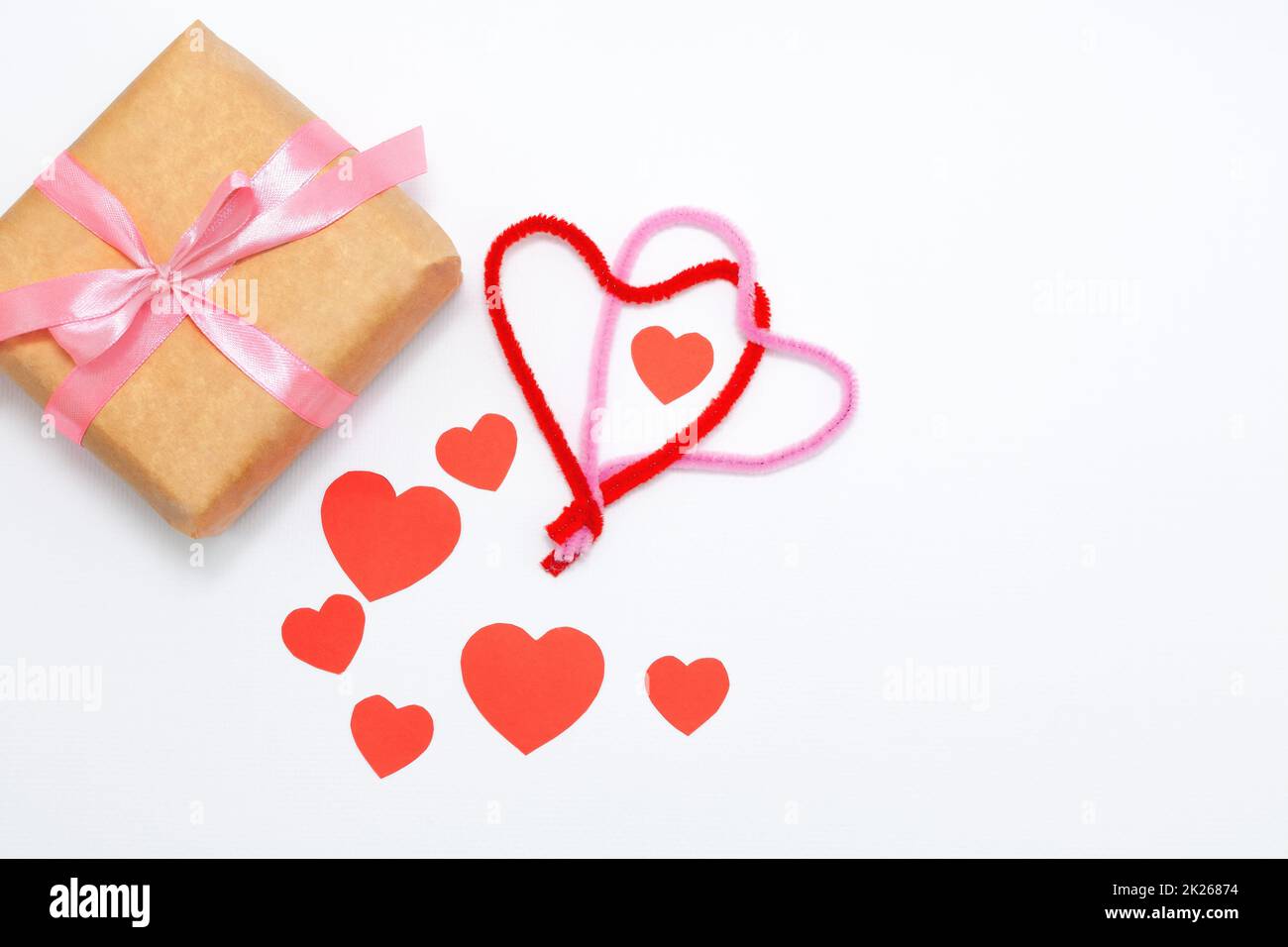 Eco gift boxes with pink ribbon and red felt hearts on white background ...