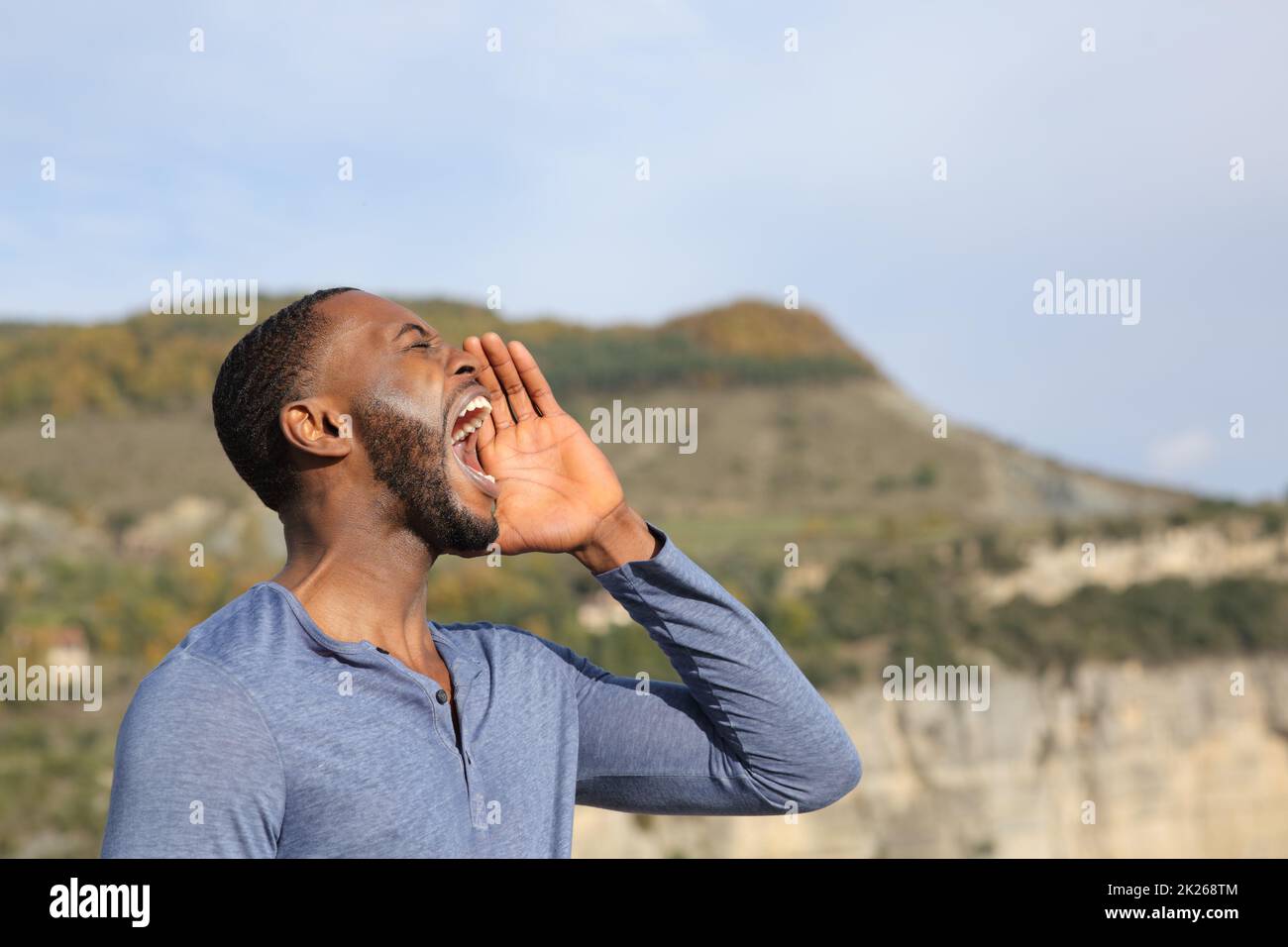Man with black skin screaming in nature Stock Photo