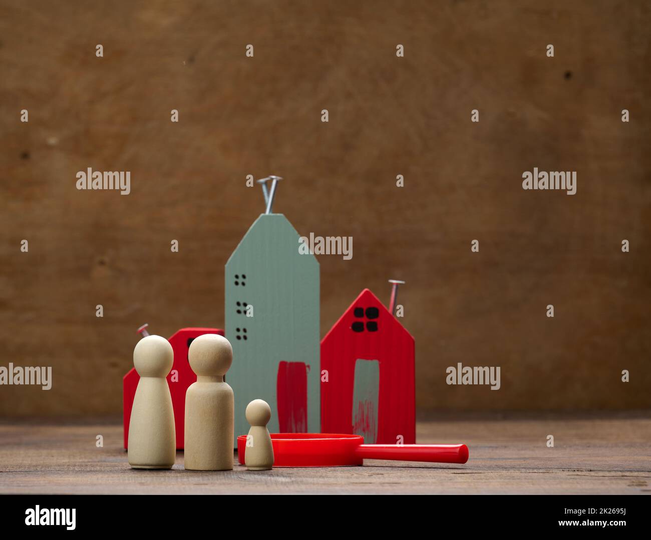 wooden family figurines, model house on a brown background. Real estate purchase, rental concept. Moving to new apartments Stock Photo