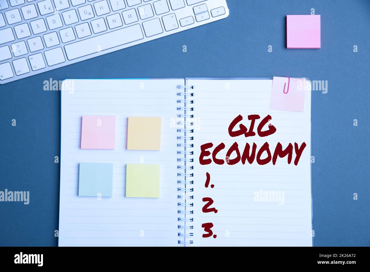 Text caption presenting Gig Economy. Business overview a market system distinguished by shortterm jobs and contracts Keyboard Over A Table Beside A Notebook And Pens With Sticky Notes Stock Photo