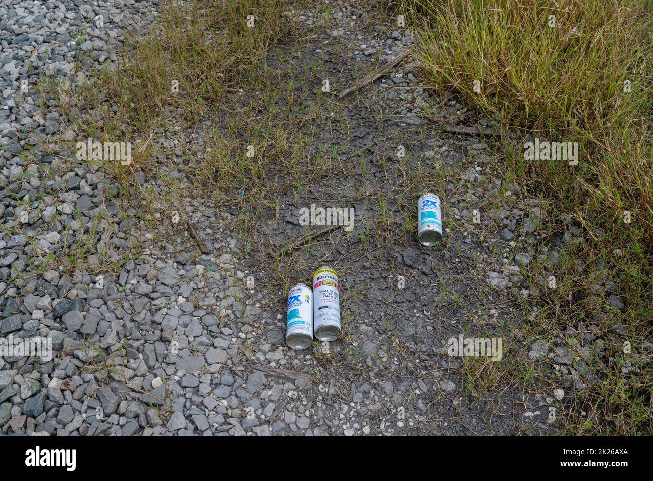 NEW ORLEANS, LA, USA - SEPTEMBER 17, 2022: Discarded paint cans left on the ground by vandals after tagging railroad car in Uptown New Orleans Stock Photo