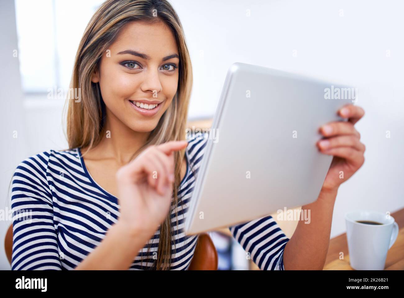 Its so easy to use. A portrait of a beautiful young professional using a tablet at her desk. Stock Photo