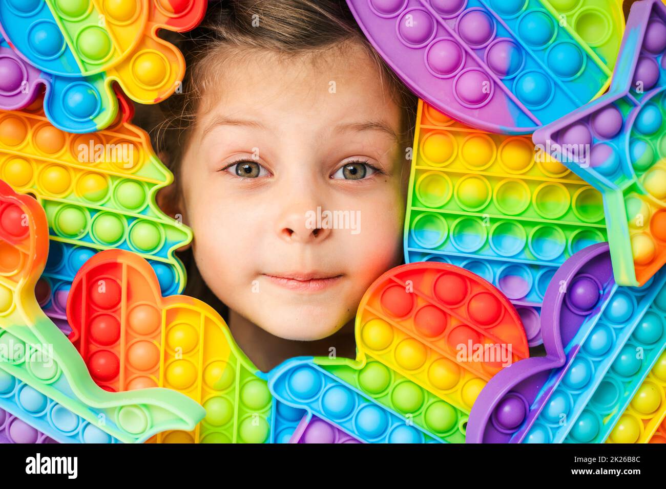 Little girl,kid,child head among many,lots of colorful pop it. Children ...