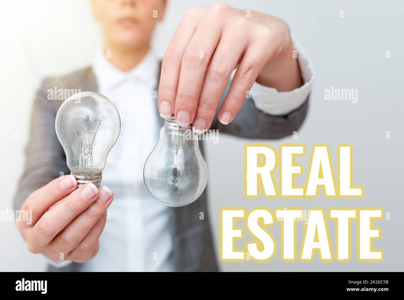 Sign displaying Real Estate. Conceptual photo total property consisting of both natural resource and building Lady outfit holding two lamps upside down presenting new technology ideas Stock Photo