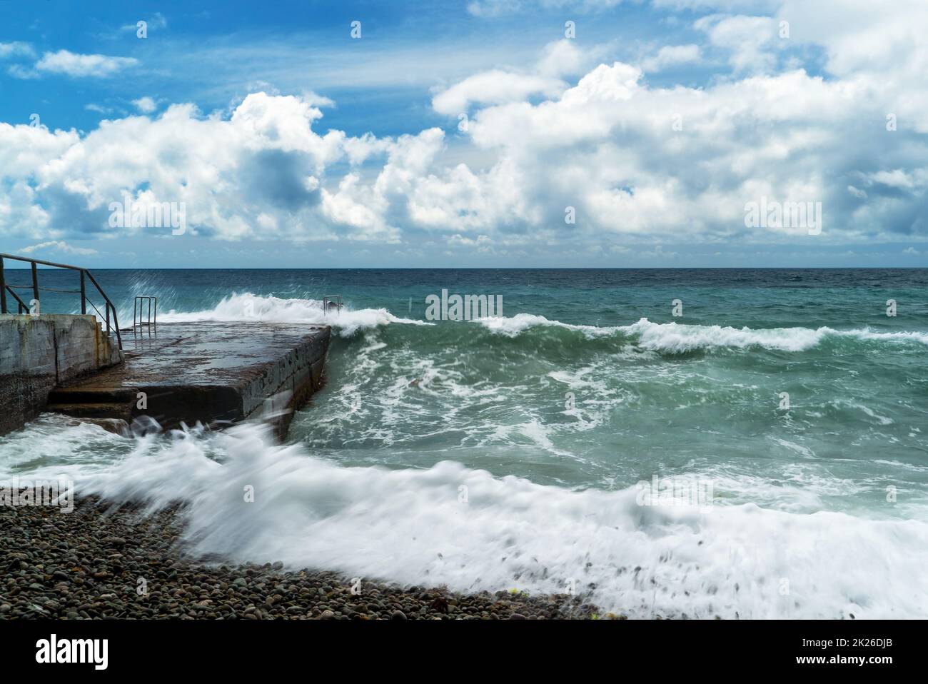 The sea is stormy. Large waves break on the breakwater .Crimea. Stock Photo