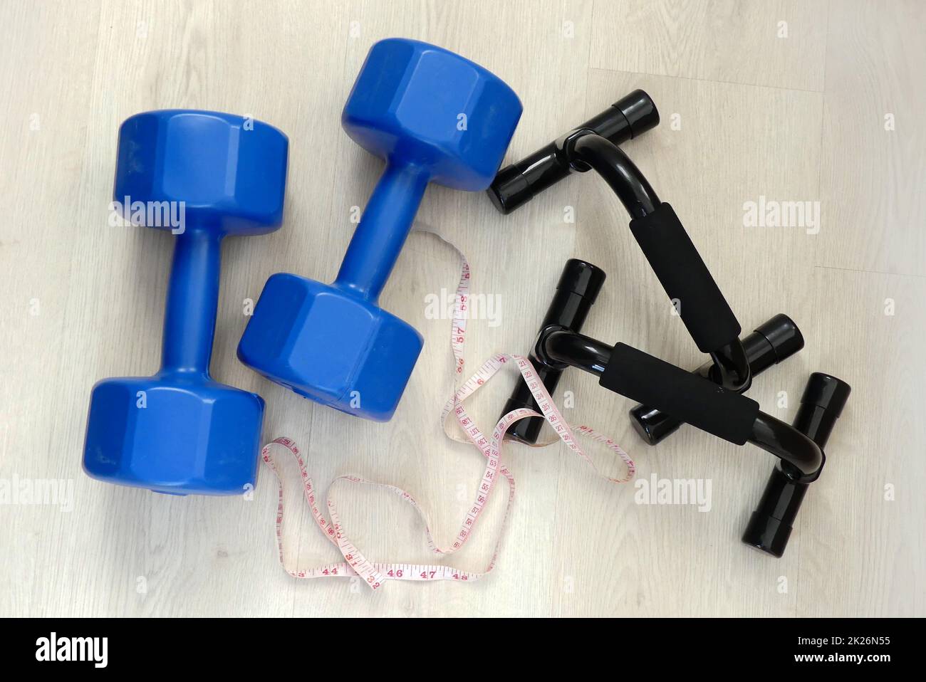 losing weight and losing weight, measuring tape in the same frame, 5 kg double hand dumbbells and push-up apparatus Stock Photo