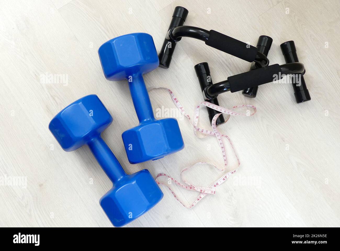 losing weight and losing weight, measuring tape in the same frame, 5 kg double hand dumbbells and push-up apparatus Stock Photo