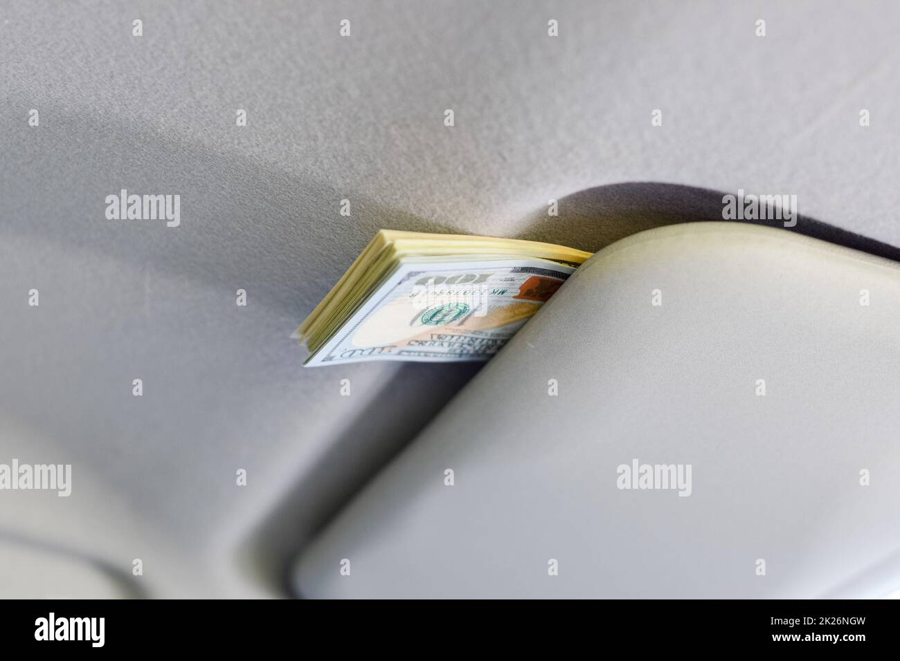 Money under the sun visor inside the car. Dollars in car Stock Photo