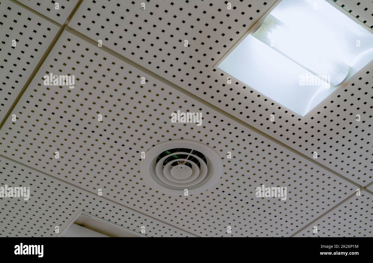 Air conditioner. Air duct and ceiling lamp light mount on ceiling of hospital, hotel, or office building. Cool system in the building. Air flow and ventilation system. AHU air conditioning system. Stock Photo