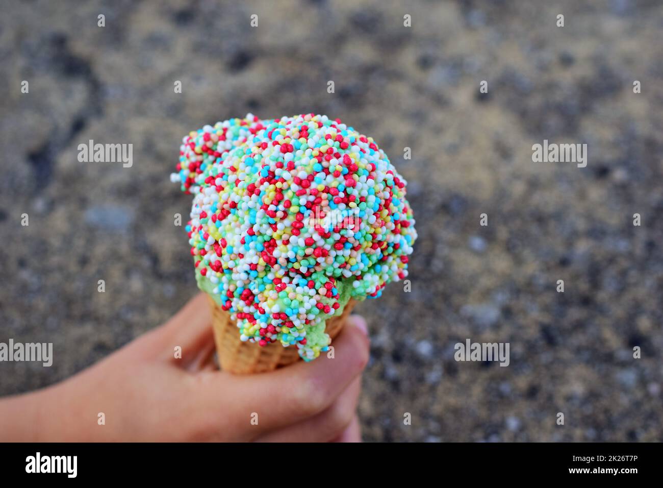 Ice cream with colorful sugar sprinkles in hand as a close-up Stock Photo