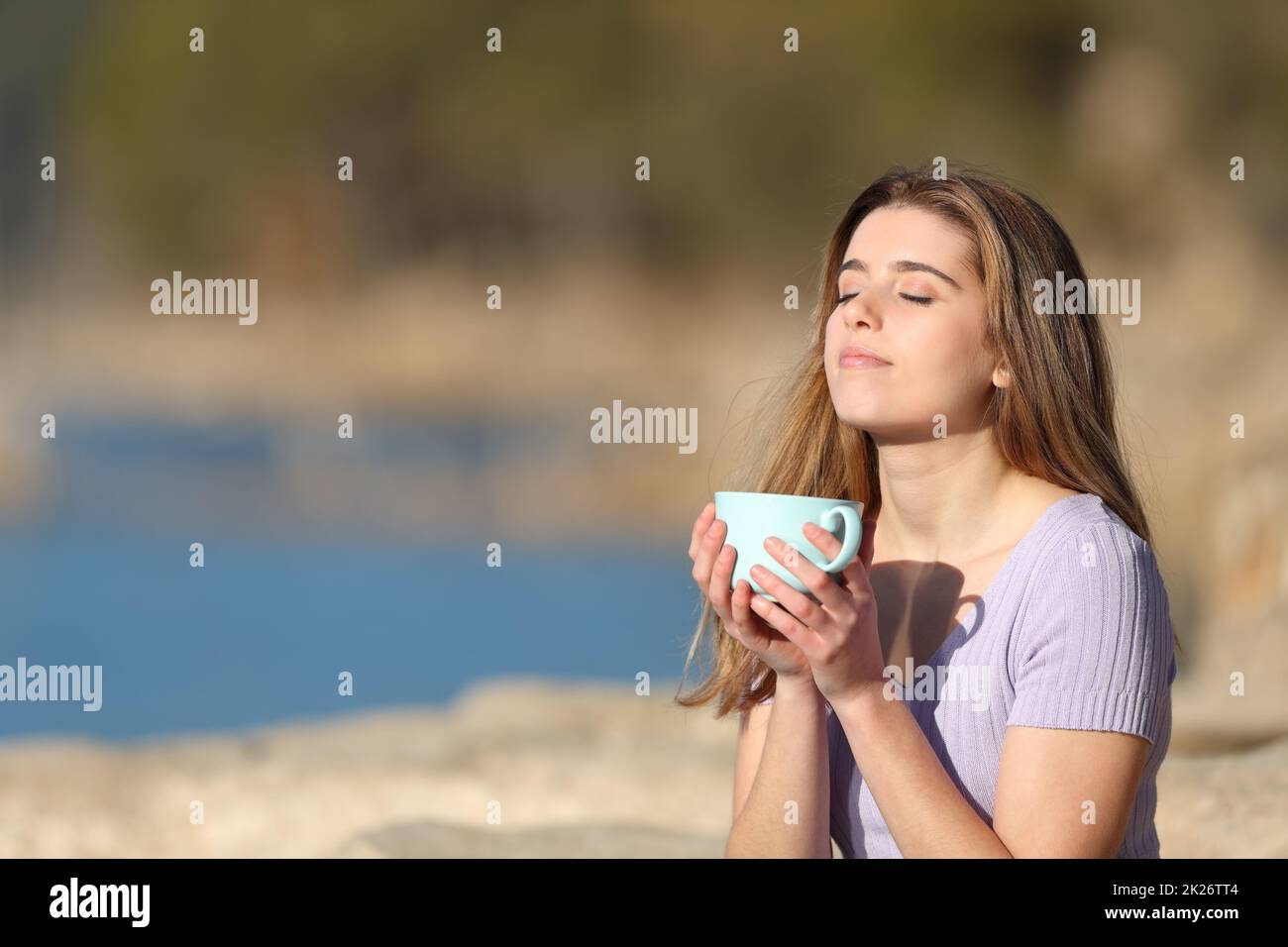 Relaxed teen drinking coffee and relaxing in nature Stock Photo
