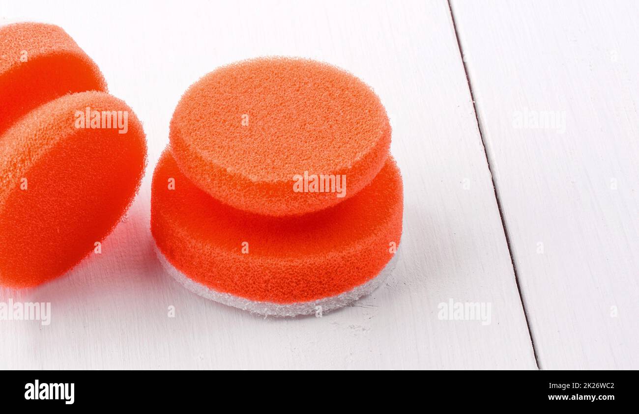 red sponges for washing dishes on white wooden backgroud Stock Photo
