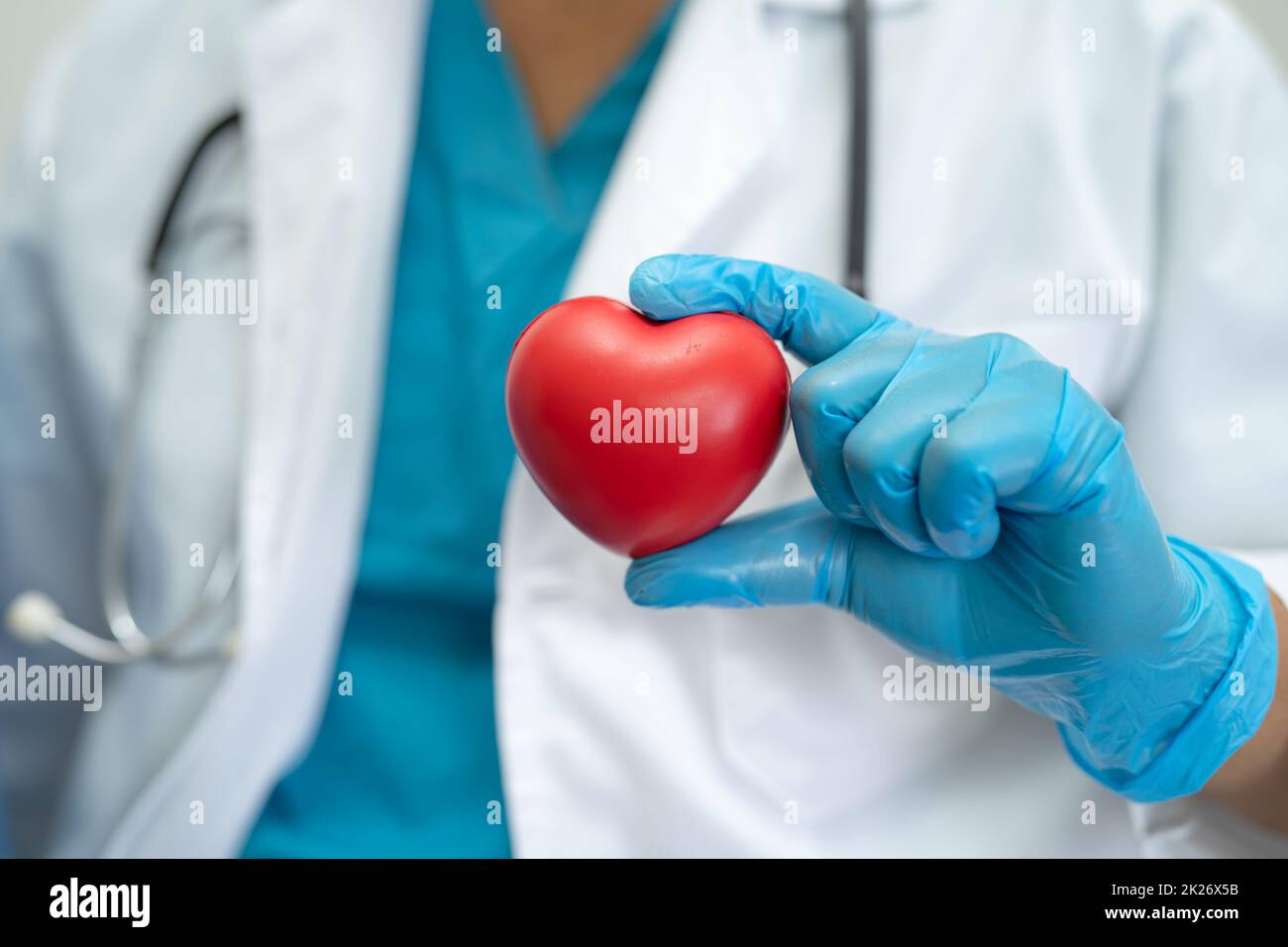 Doctor wearing ppe with mask for protect coronavirus holding red heart. Stock Photo