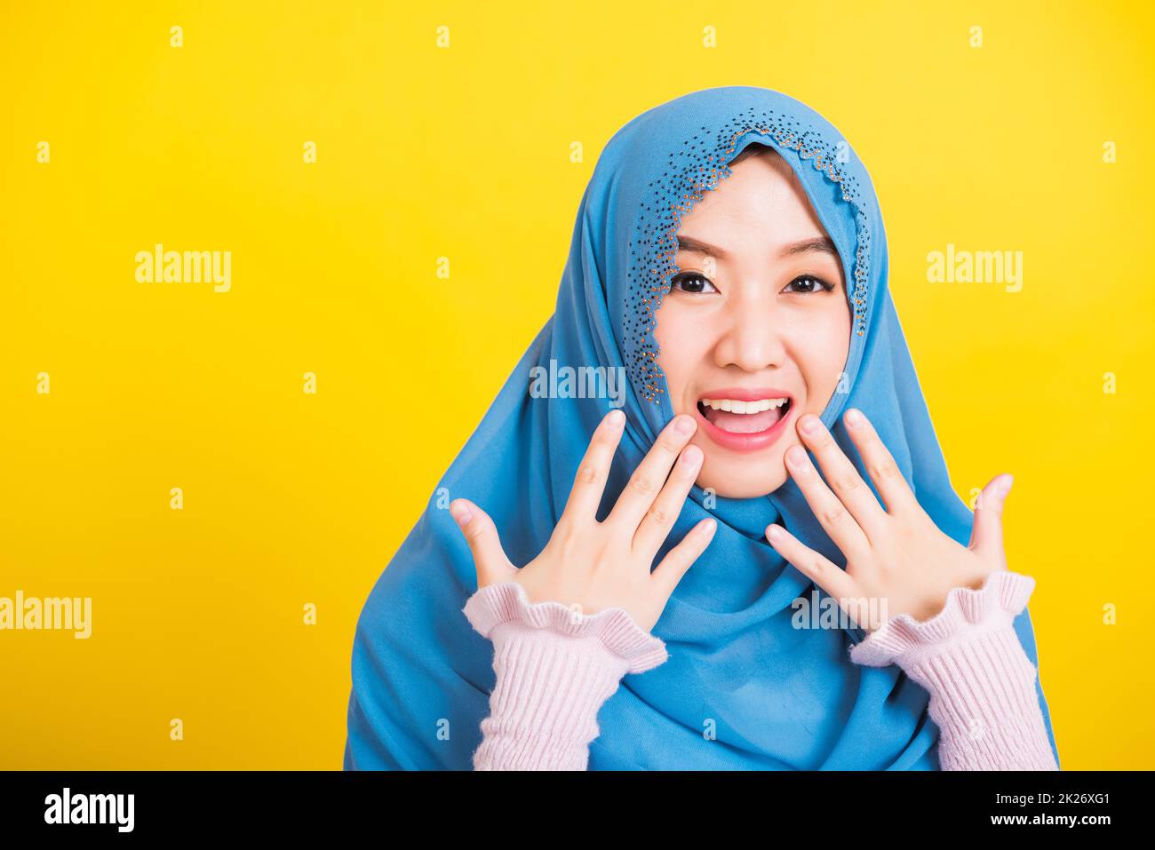 Asian Muslim Arab woman Islam wear hijab she shocking open mouth touching her cheeks Stock Photo