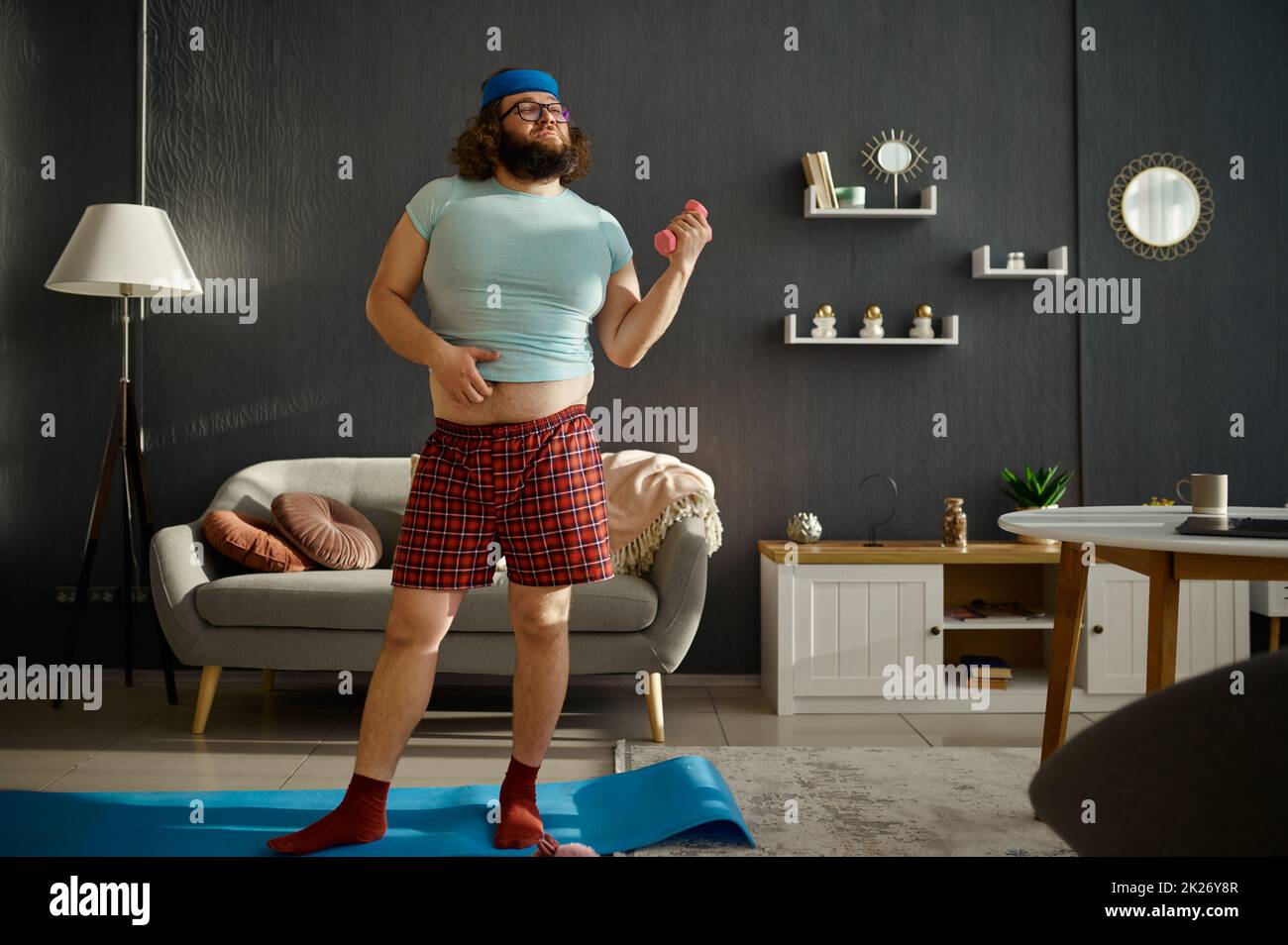 Funny man doing morning workout with dumbbells Stock Photo