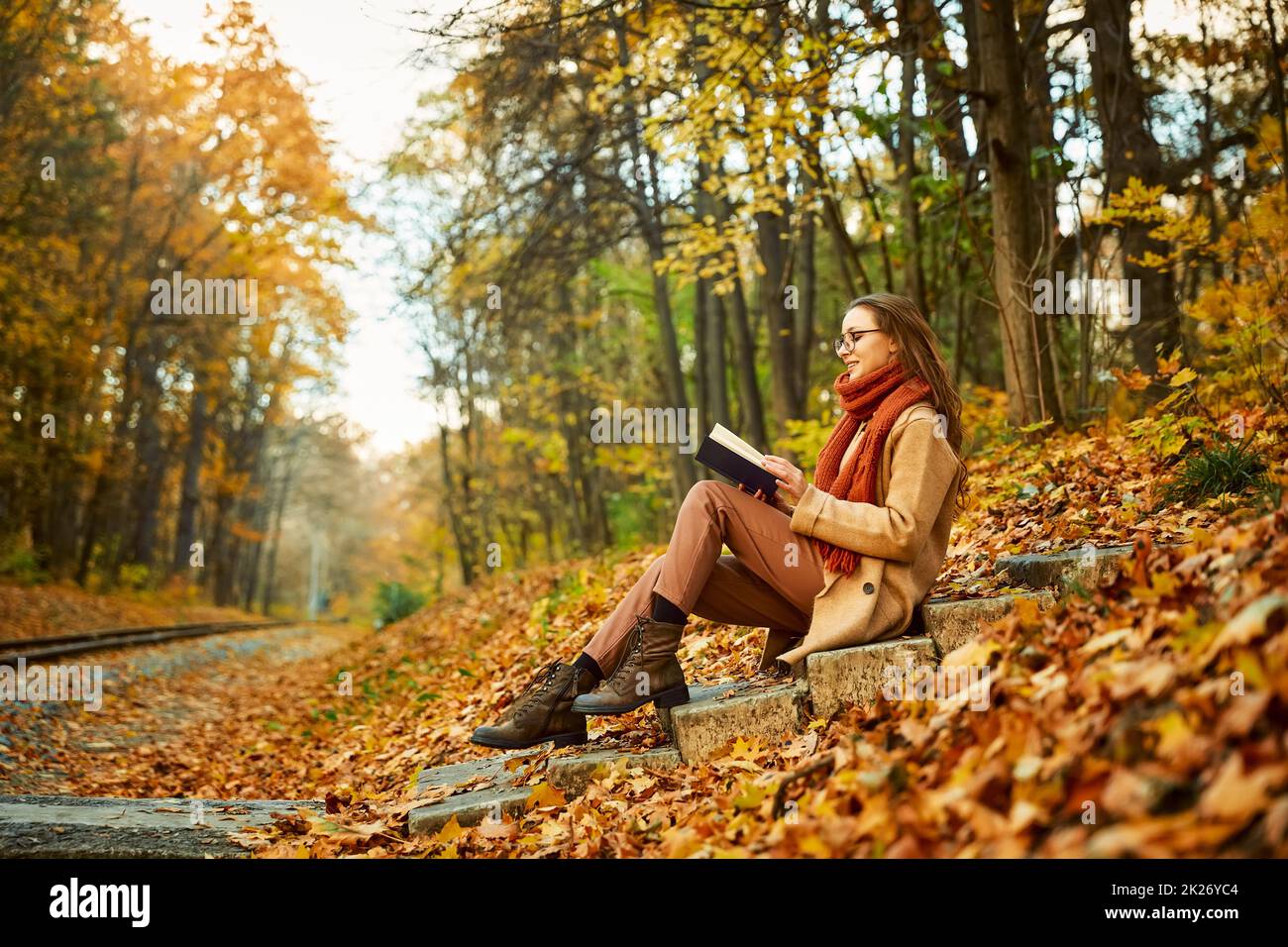 Young woman with book over autumn background Stock Photo