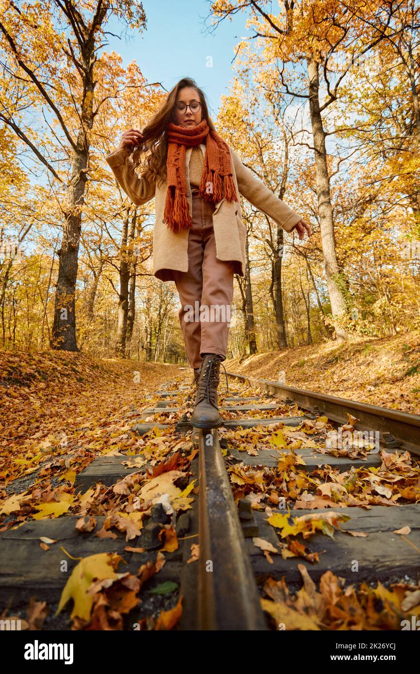 Woman balancing on railway over autumn background Stock Photo