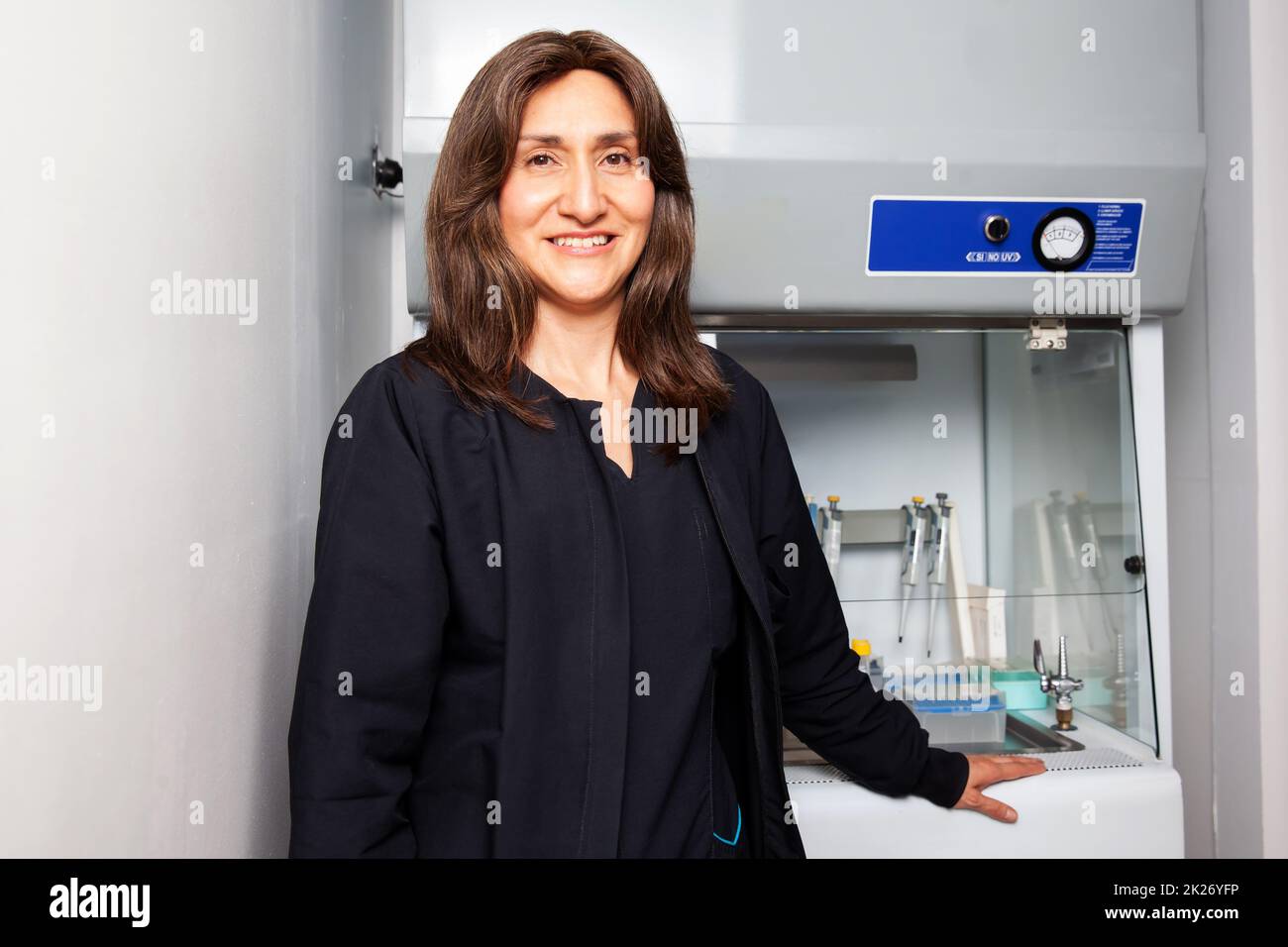 Portrait of a female scientist next to the laminar air flow cabinet in the laboratory. Stock Photo