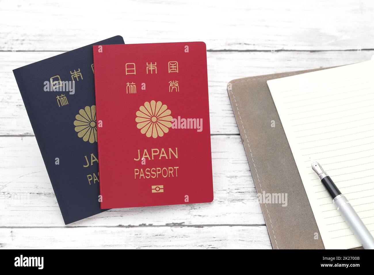 Japanese passport with leather notebook on white wooden background