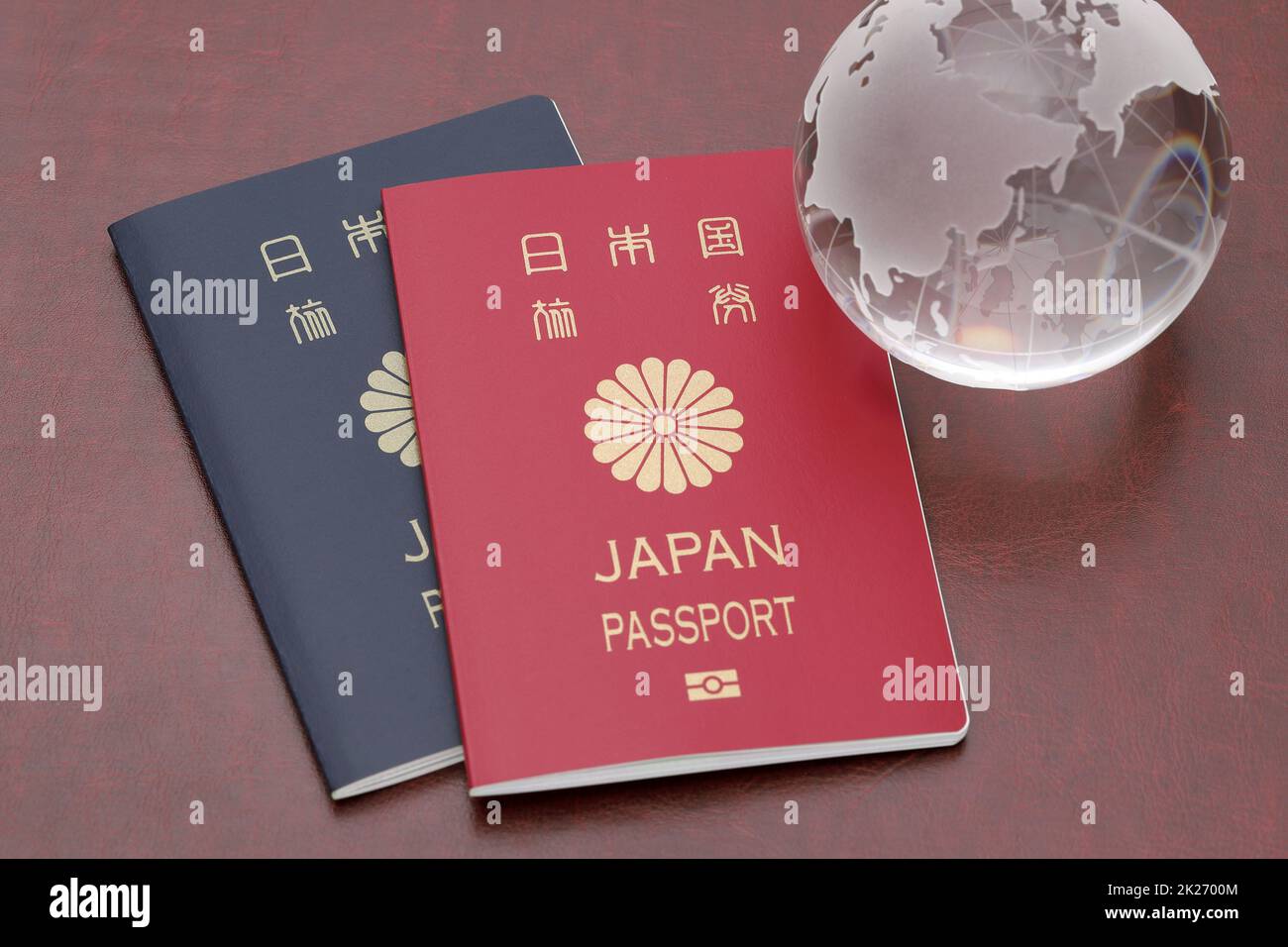 Japanese passport with glass globe on red leather background Stock Photo