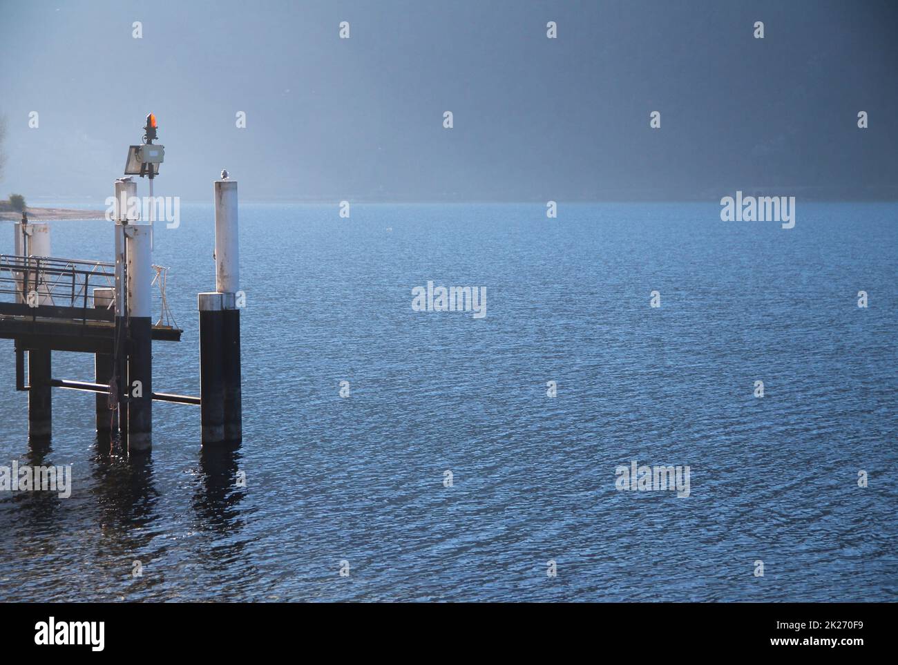 The ferry boat docking station of Abbadia Lariana during a winter sunrise on Como Lake Stock Photo