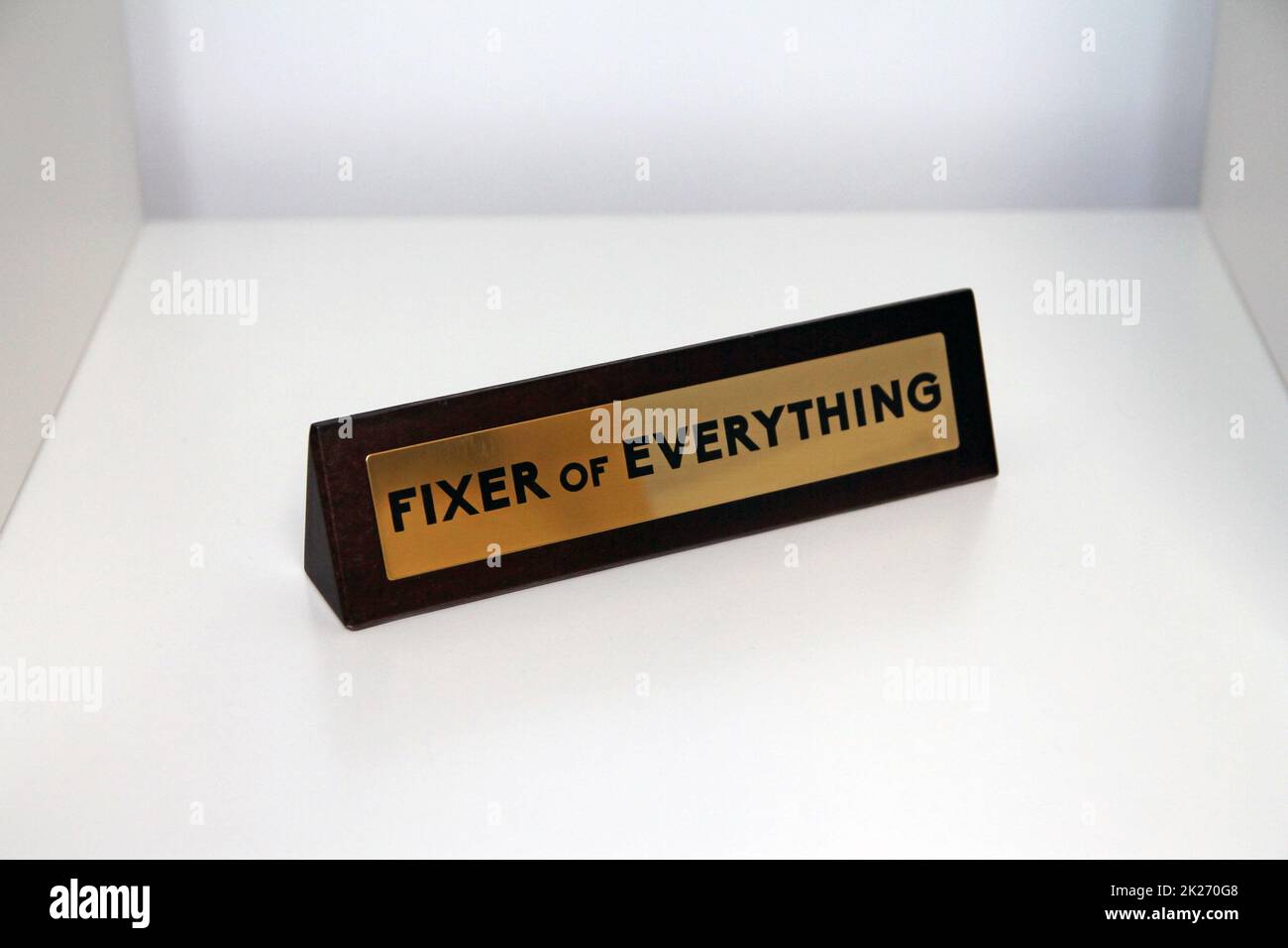 Fixer of Everything wood and metal sign on a white shelf Stock Photo