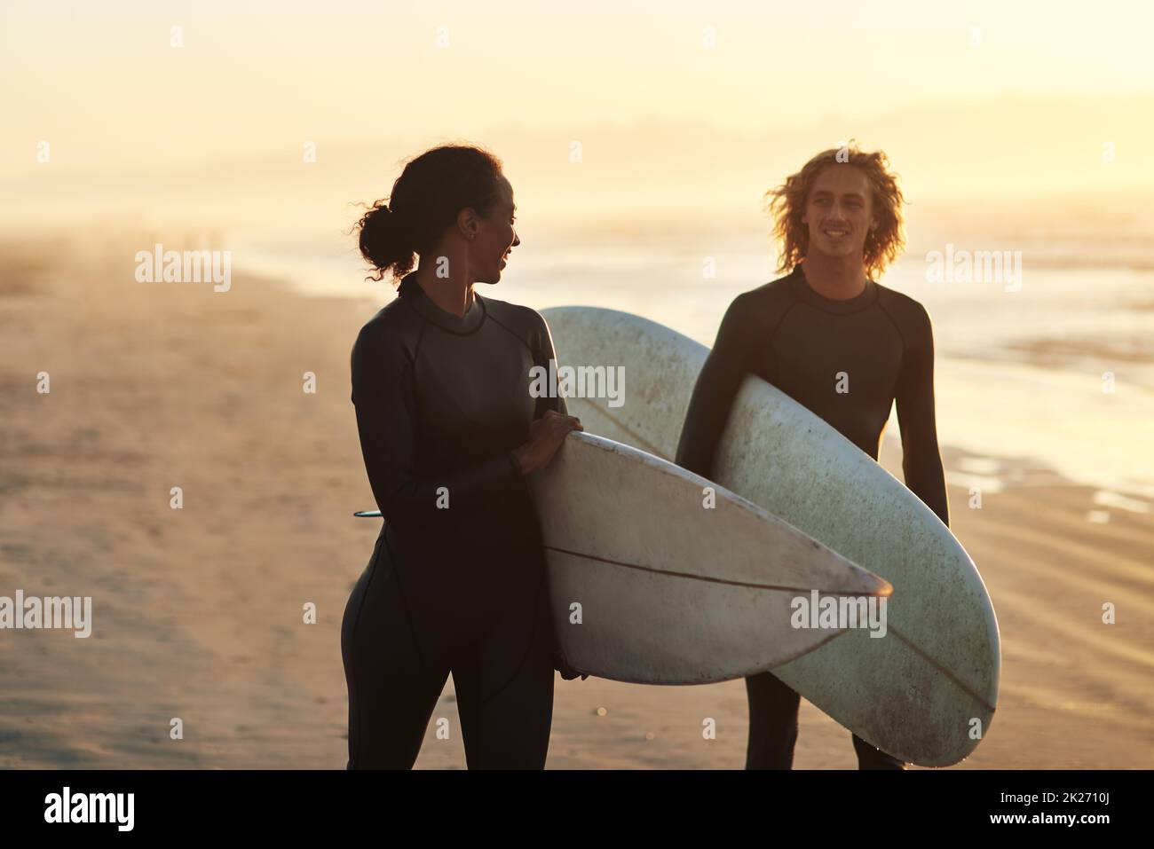 The beach is our happy place. Shot of a cheerful young couple going surfing at the beach. Stock Photo
