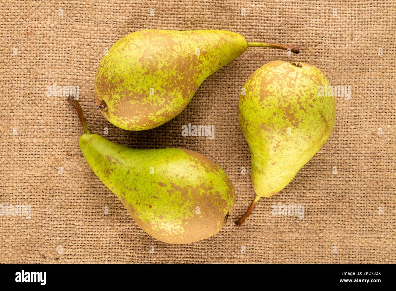 Thre juicy pears on a jute cloth, macro, top view. Stock Photo